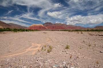 Desert background. View of the sand, red canyon and colorful mountains under a magical sky.