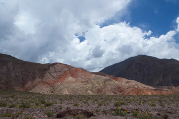 The Andes mountain range. View of the valley and colorful mountains and sandstone formations under a beautiful sky with white clouds.