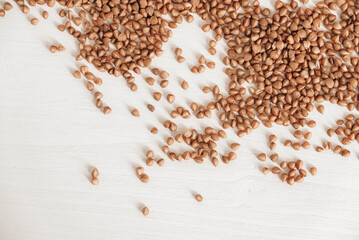 Buckwheat is randomly scattered on a white background. Top view. Copy, empty space for text