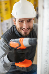 portrait of male construction worker usinga cordless drill