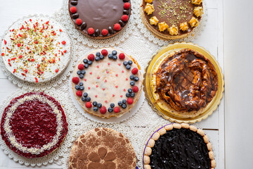 selection of cheesecakes, profiterole, carrot cake, tartlet, fruit cakes for mothersday, valentines day on white background