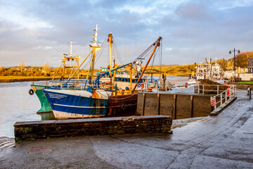 Fishing trawlers moored at Kirkcudbright harbour on the River Dee at sunset