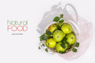 Green apples in a wicker bag on a white background with easy removable sample text. Healthy season foods with lots of vitamins. Local market, harvest, farm fruits. Eco friendly shopping