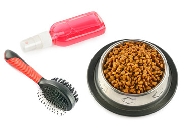 Dry dog treats in bowl, hairbrush and shampoo isolated on white.