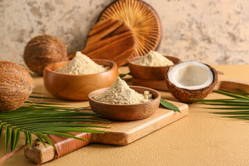 Bowls with coconut flour on color background