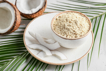 Bowl with coconut flour on light background