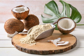 Scoop with coconut flour on light wooden background