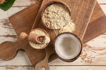Fototapeta na wymiar Bowl with coconut flour and scoop on wooden background