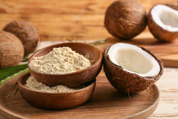 Bowls with coconut flour on wooden background