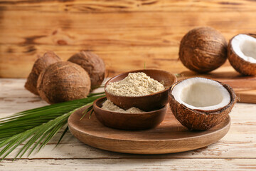 Bowls with coconut flour on wooden background