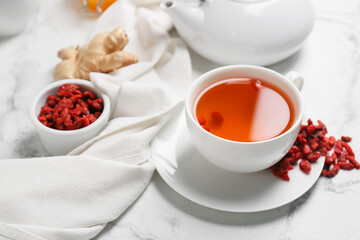 Obraz na płótnie Canvas Cup with goji tea on light background
