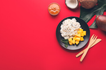 Plate with tasty rice and mango on color background