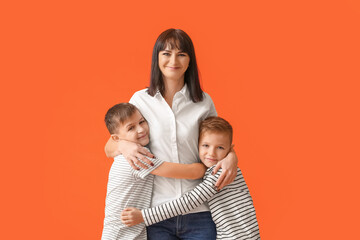 Happy mother and cute children on color background