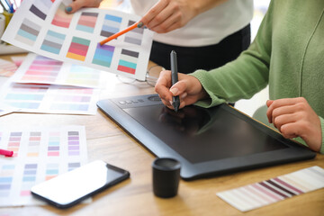 Female designer with colleague working in office