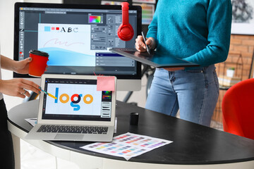 Female designer with colleague working in office