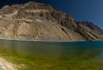 The colorful lake called Inca Lagoon in the Andes mountain range. The blue glacier water and yellow...