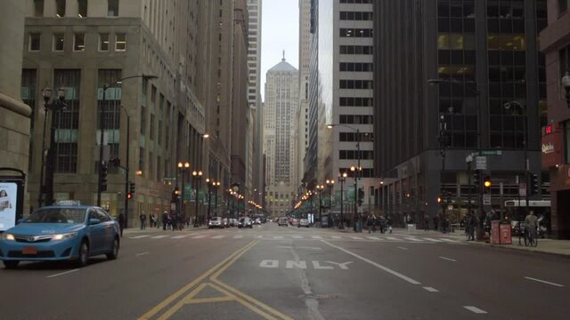 Lockdown time lapse shot of vehicles and commuters on street amidst buildings in city - Chicago, Illinois