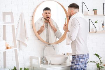 Man suffering from pain while brushing teeth in morning