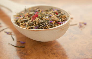 Fototapeta premium Tea in a wooden spoon on a wooden background close up