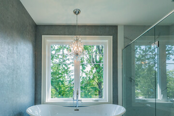 Chandelier over bathtub by a glass shower stall bathroom modern design