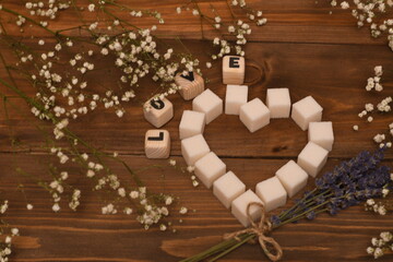 heart and the word love in flowers on a wooden table