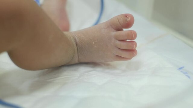 The baby moves his fingers, foot and leg. Baby, newborn in infant incubator. Measuring pulse, heartbeat and SpO2