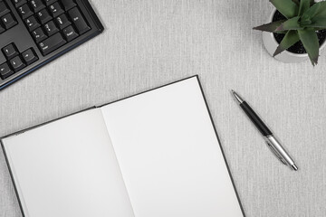 Livre ouvert avec espace vide pour inscriptions avec un clavier d'ordinateur posés sur un espace...