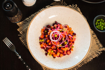 Vinaigrette. Traditional russian beetroot salad with boiled vegetables, pickled cucumbers, sour cabbage, olive oil and green canned peas. Vegetarian healthy dinner. Served in restaraunt.