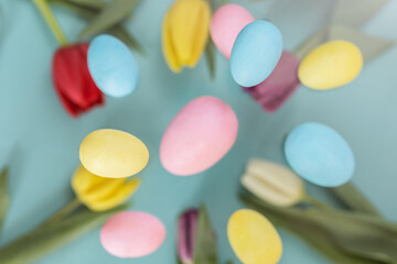 Easter background. Levitating Easter eggs and tulips in pastel colors on a blue background. composition Easter greeting card, pattern