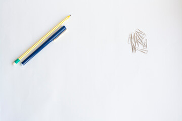 Pencil and pen and paper clips on a white background, copy space
