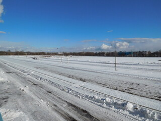 winter road in the snow, race track in winter, beautiful landscape with bright sky and clouds on hippodrome 