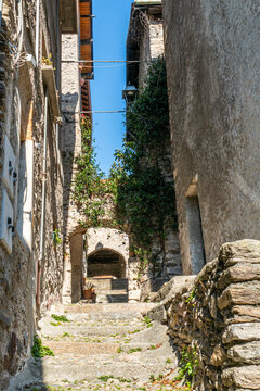 The interior of Corenno Plinio with narrow stone streets, arches and flowers
