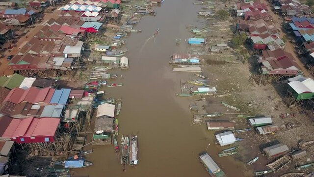 aerial titling drone shot of Kampong Phluk village that is built on stilts on the river