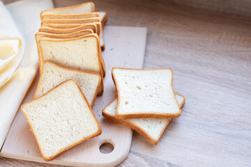 Slices of wheaten bread on a cutting board on the kitchen table, sliced loaf of bread.