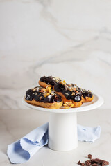 Traditional french dessert - eclairs with chocolate glaze on a cake stand