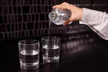 woman hands pouring water into a glass. healthy start of morning with clean water