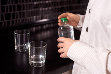 woman hands open bottle of water. healthy start of morning with clean water