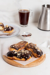 Traditional french dessert - eclairs with chocolate glaze. Eclairs on chalkboard with coffee.