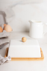 Block of butter in butter dish on a marble background. 