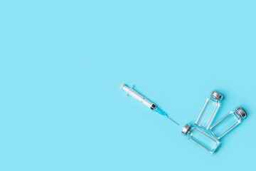 syringes and ampoules with vaccinations on a blue background. vaccination against covid-19. the principle of collective immunity.