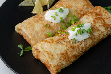 stuffed meat pancakes with herbs and cheese on a black plate