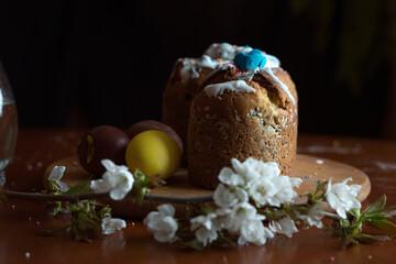 Easter, holidays and tradition concept. Easter cake. Colorful Easter eggs painted in pastel colors and blossom cherry.