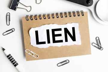 lien. Text on white notepad paper on light background