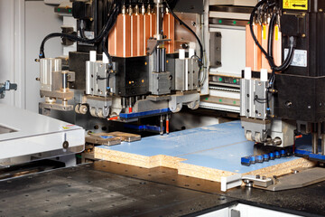 The process of manufacturing cabinet furniture from chipboard on a modern automatic drilling and milling machine.