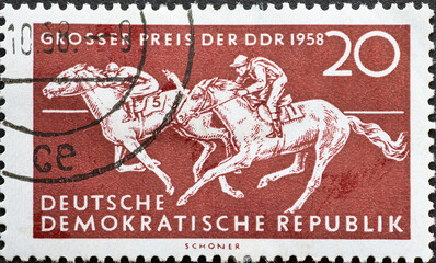GERMANY, DDR - CIRCA 1958 : a postage stamp from Germany, GDR showing Two horses with jockey at a horse race. Text: Horse racing Grand Prix of the GDR