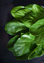 Fototapeta na wymiar Washed fresh spinach on a black background
