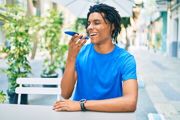 Young african american man smiling happy sending audio message using smartphone at terrace..