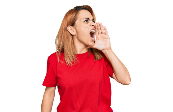 Hispanic young woman wearing casual red t shirt shouting and screaming loud to side with hand on mouth. communication concept.
