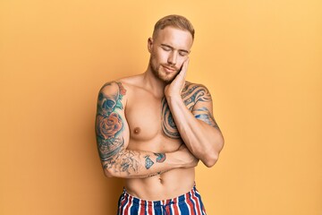 Fototapeta premium Young caucasian man wearing swimwear shirtless thinking looking tired and bored with depression problems with crossed arms.