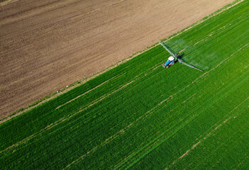 Aerial view of modern farm machine sprayer on green field. Modern technology of agriculture